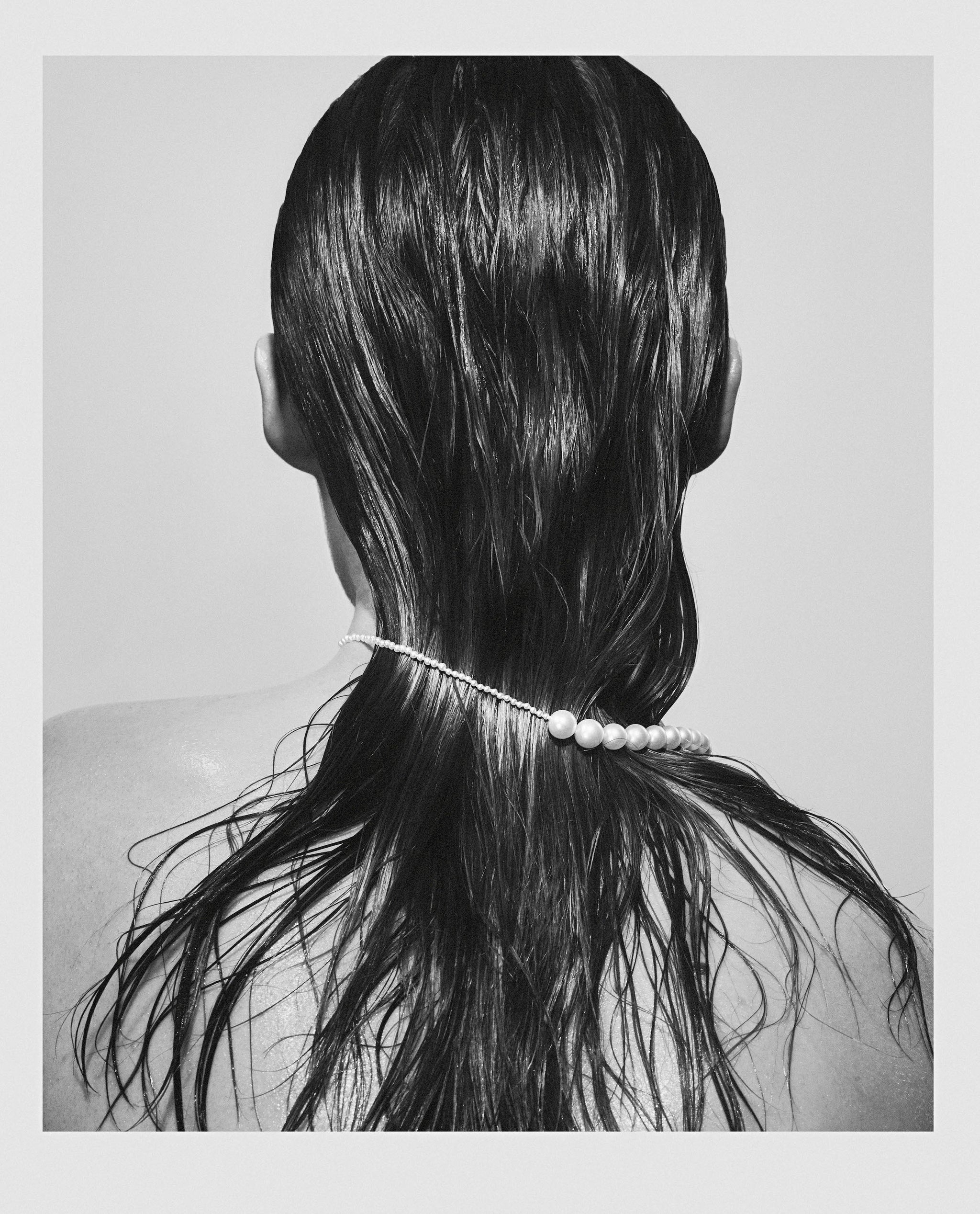 Photography of model showing the back of her head with a Peggy pearl necklace around her neck