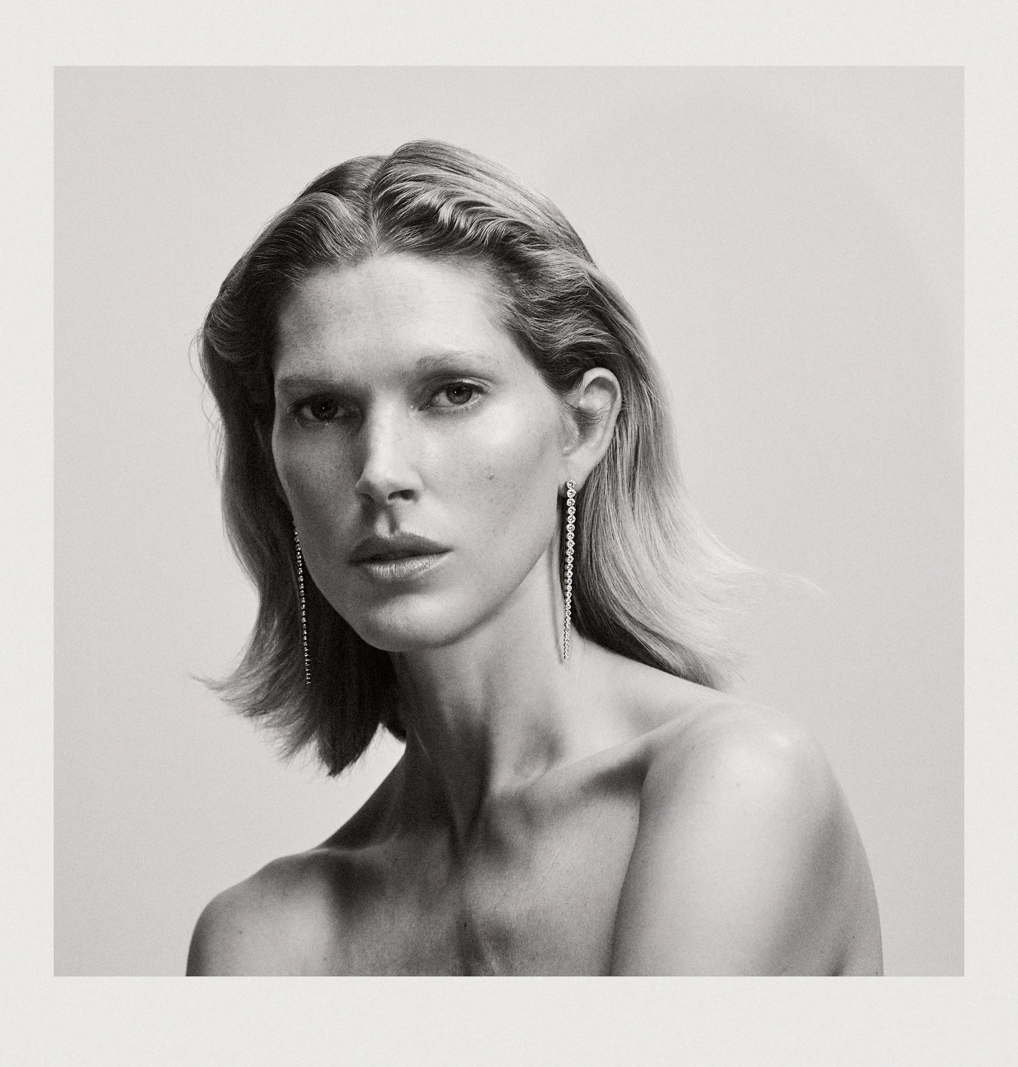 Black and white photography of model wearing Sandro Grande diamond earrings