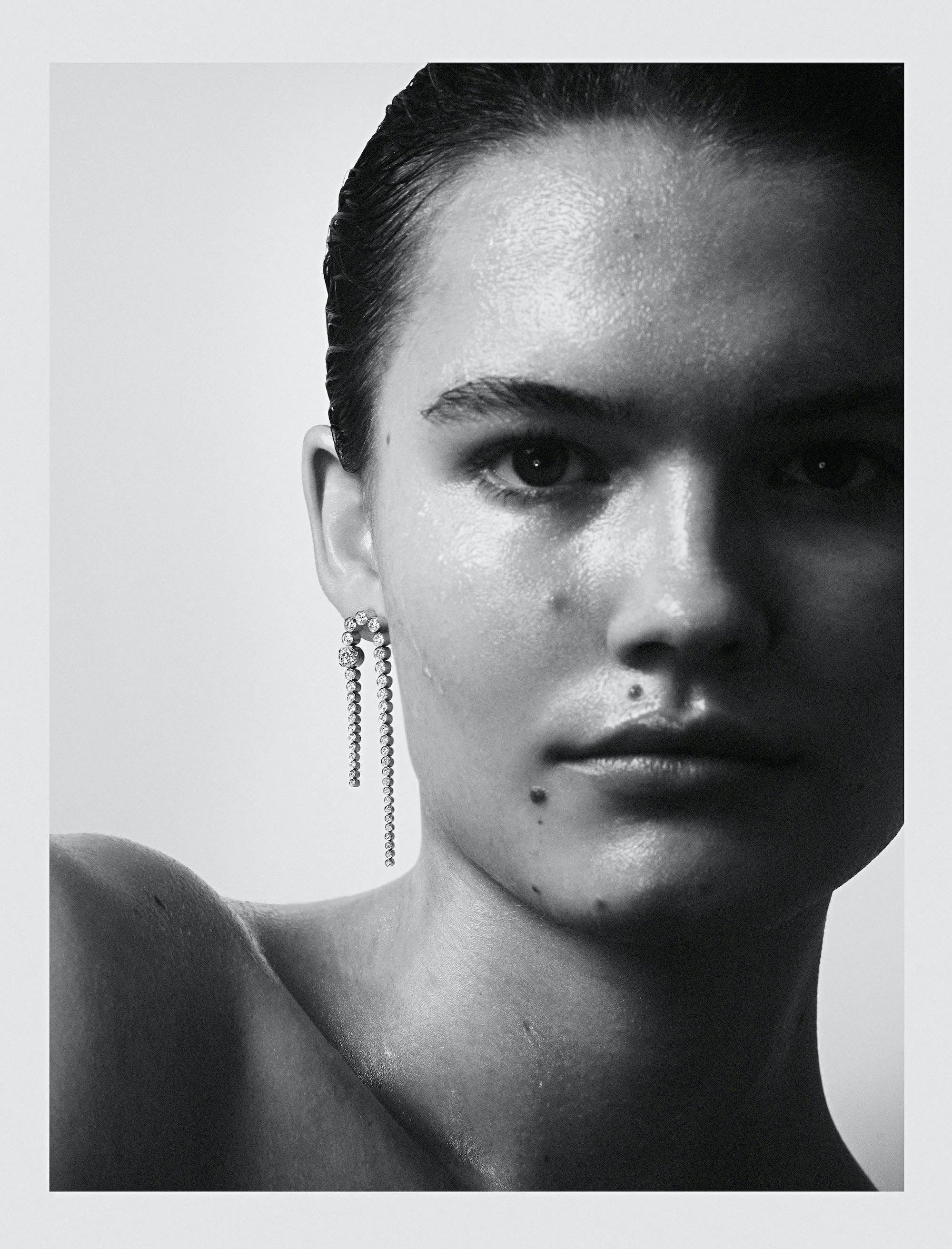 Black and white photography of model wearing Nuit Royale diamond single earring