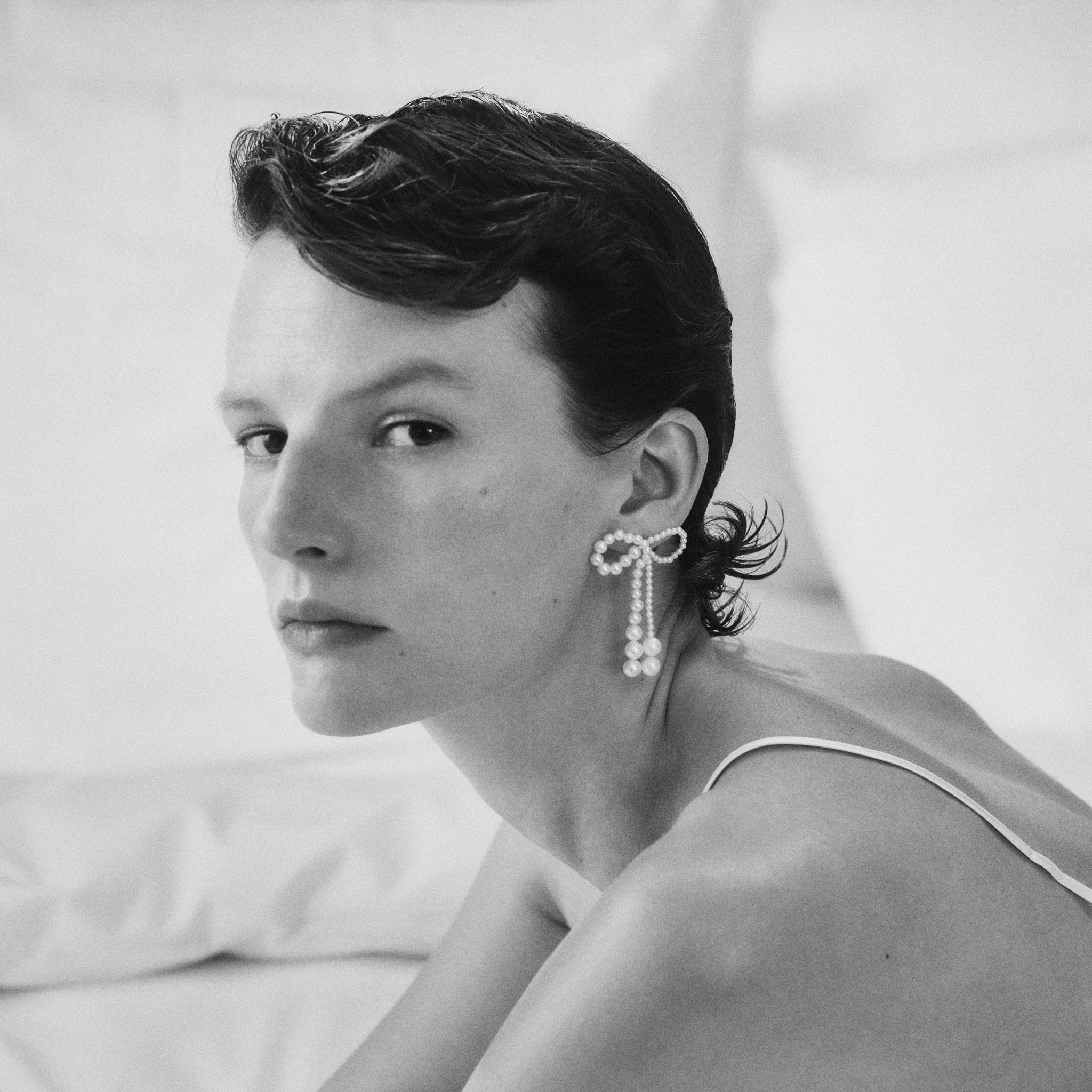 Model wearing Grande Rosette de Perle pearl earrings from the Autumn & Winter 2022 collection