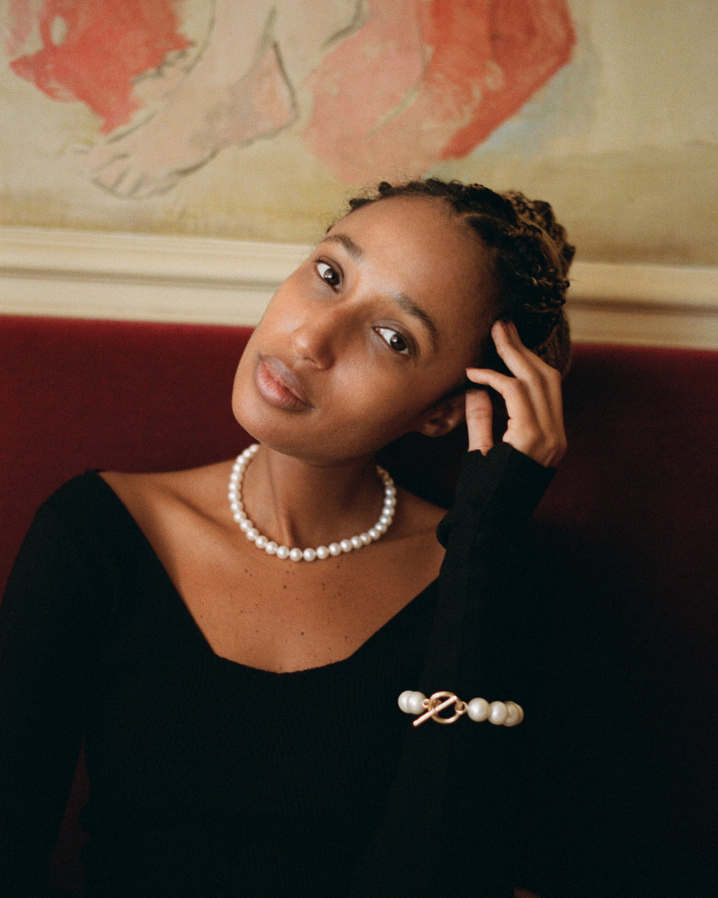 Model is sitting wearing the La Belle freshwater pearl long necklace and the matching La Belle Perle bracelet made with large freshwater pearls and a yellow gold lock.