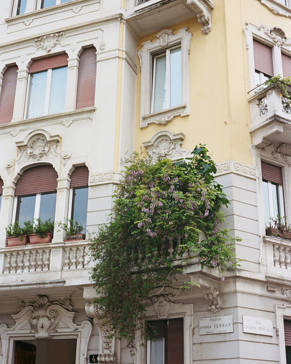 Decorative building facade with plants and architectural details in Italy.