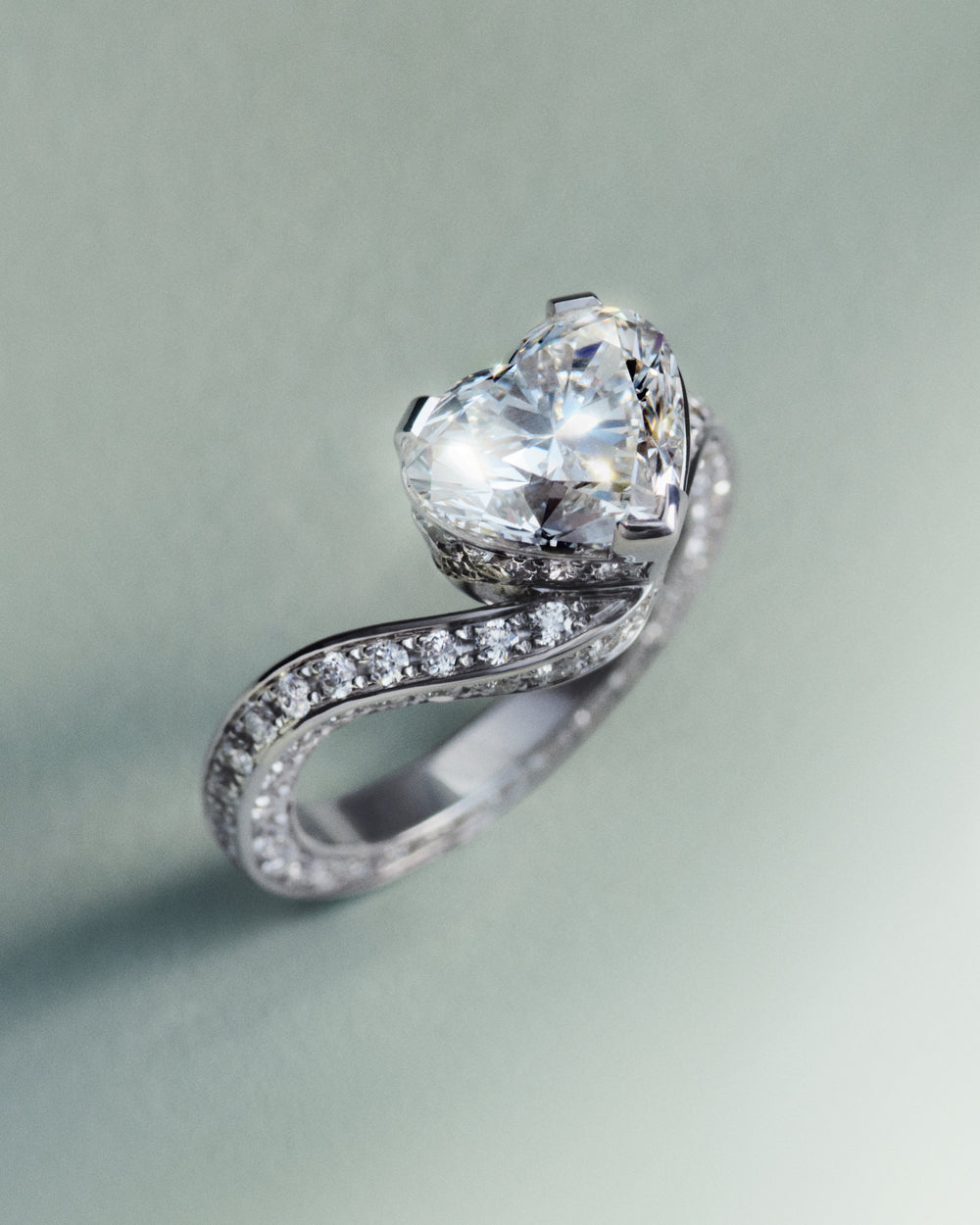 Sky 3 diamond ring with a heart shaped stone on a light green background.