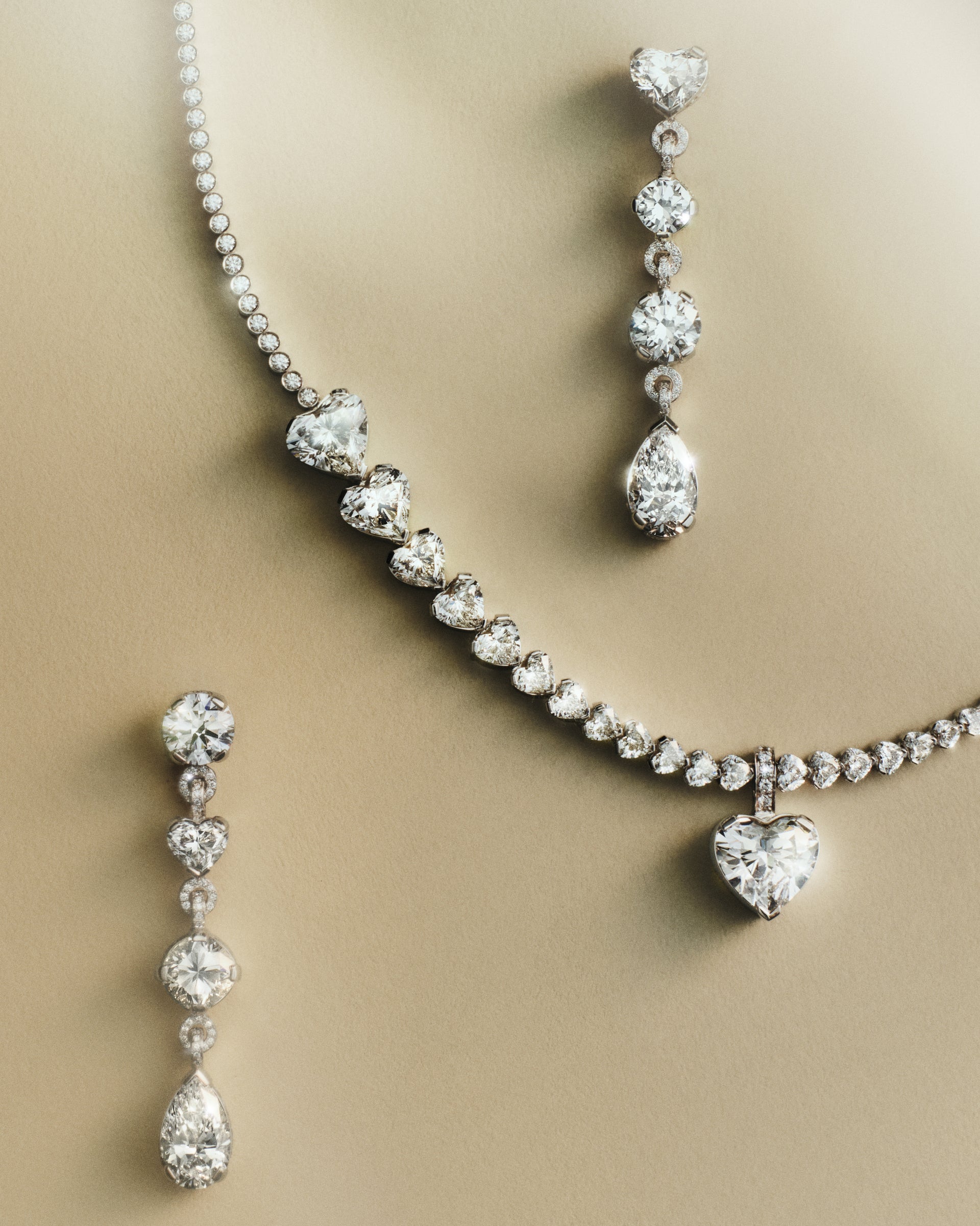Sky 4 diamond necklace and Sky 5 diamond earrings on a beige background
