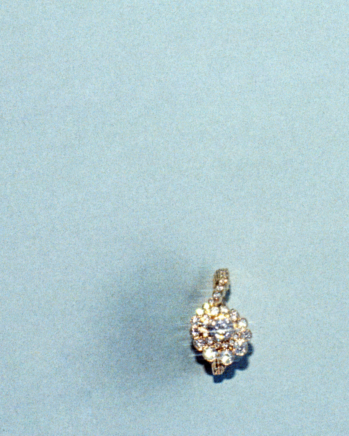 Diamond ring, photographed on a pale blue textured background.