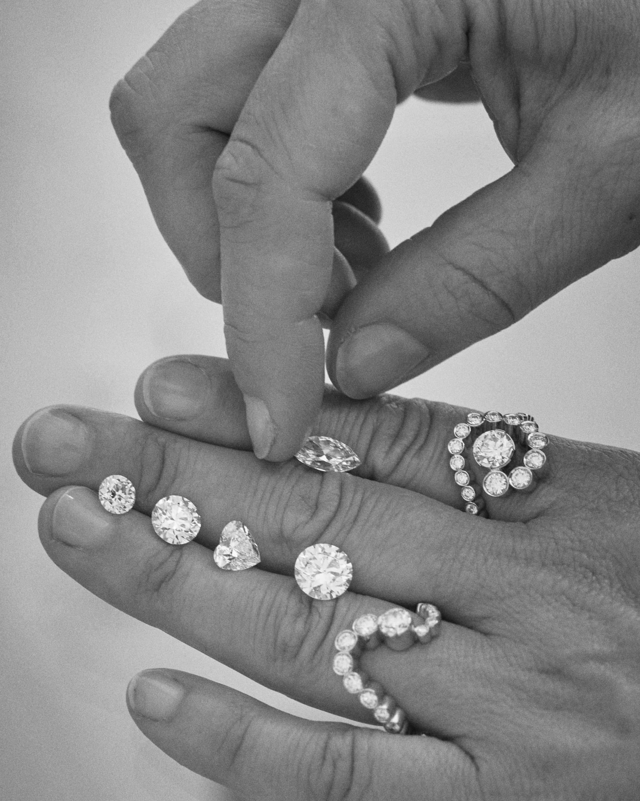 Loose diamonds on hand with rings.