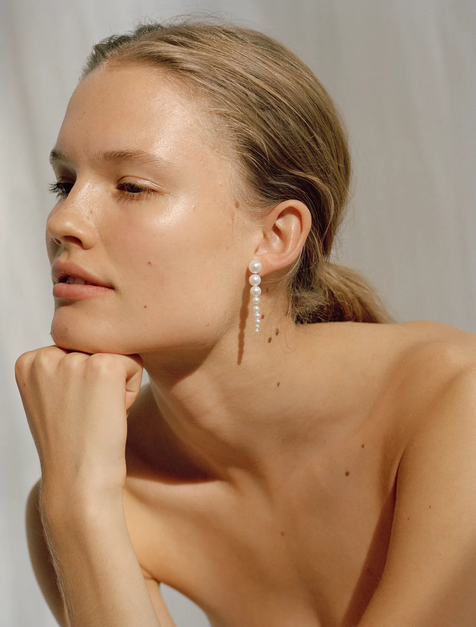 Model wearing Sienna earrings which are handmade in 14K yellow gold with freshwater pearls 